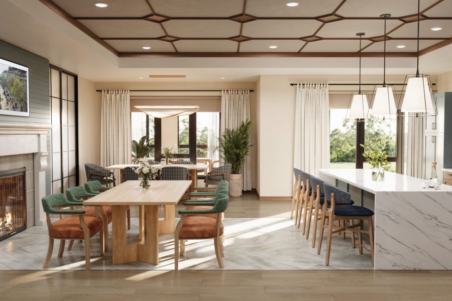 The Ensley 55+ Luxury Apartments with Modern open kitchen and dining area with marble island, wooden table, green chairs, and large windows.