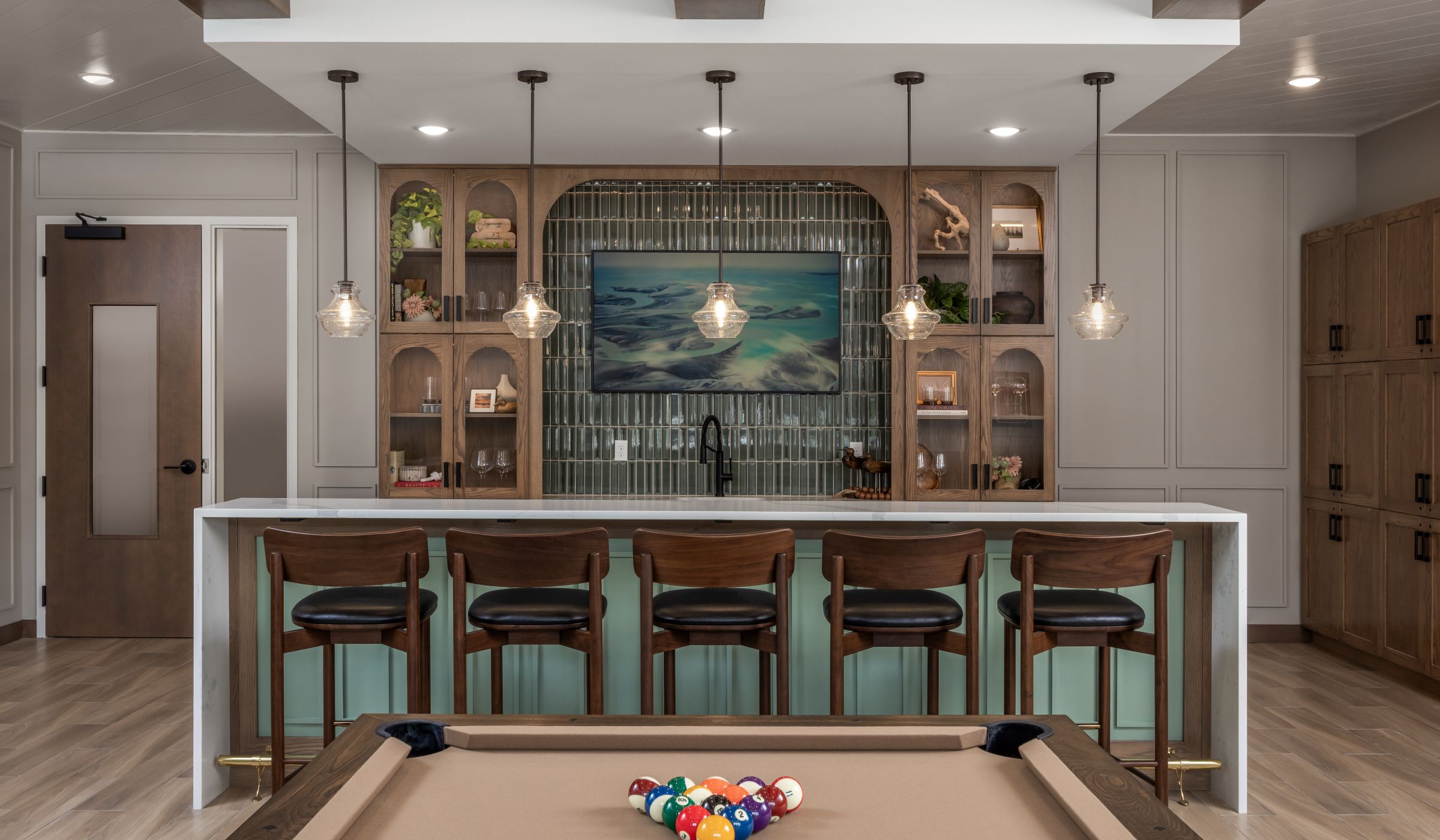 The Ensley 55+ Luxury Apartments with Modern kitchen with beige cabinets, tiled backsplash, stove, sink, and open shelves with dishes and decor.