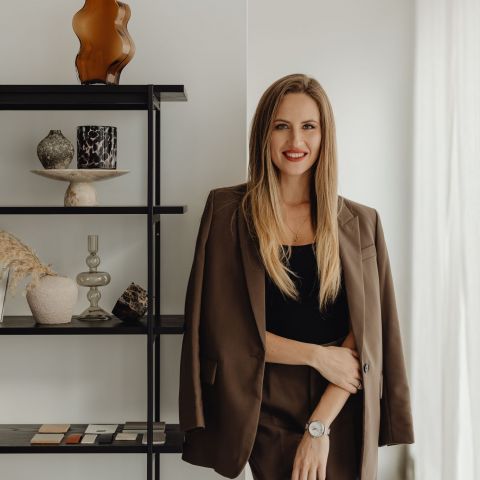The Ensley leasing representative in business attire smiling in modern office
